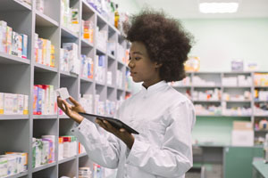 A pharmacist is looking at a medication bottle.